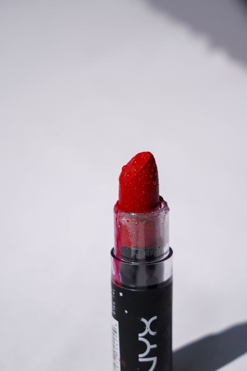 Free Close-up of a vivid red lipstick with dewdrop effect, perfect for fashion and beauty themes. Stock Photo