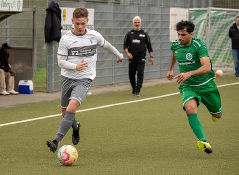 Two soccer players competing in a fast-paced match on an outdoor field.