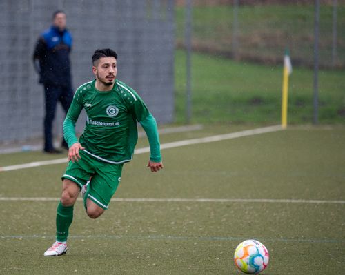 Free Professional male soccer player in motion on a rainy football field, wearing green uniform. Stock Photo