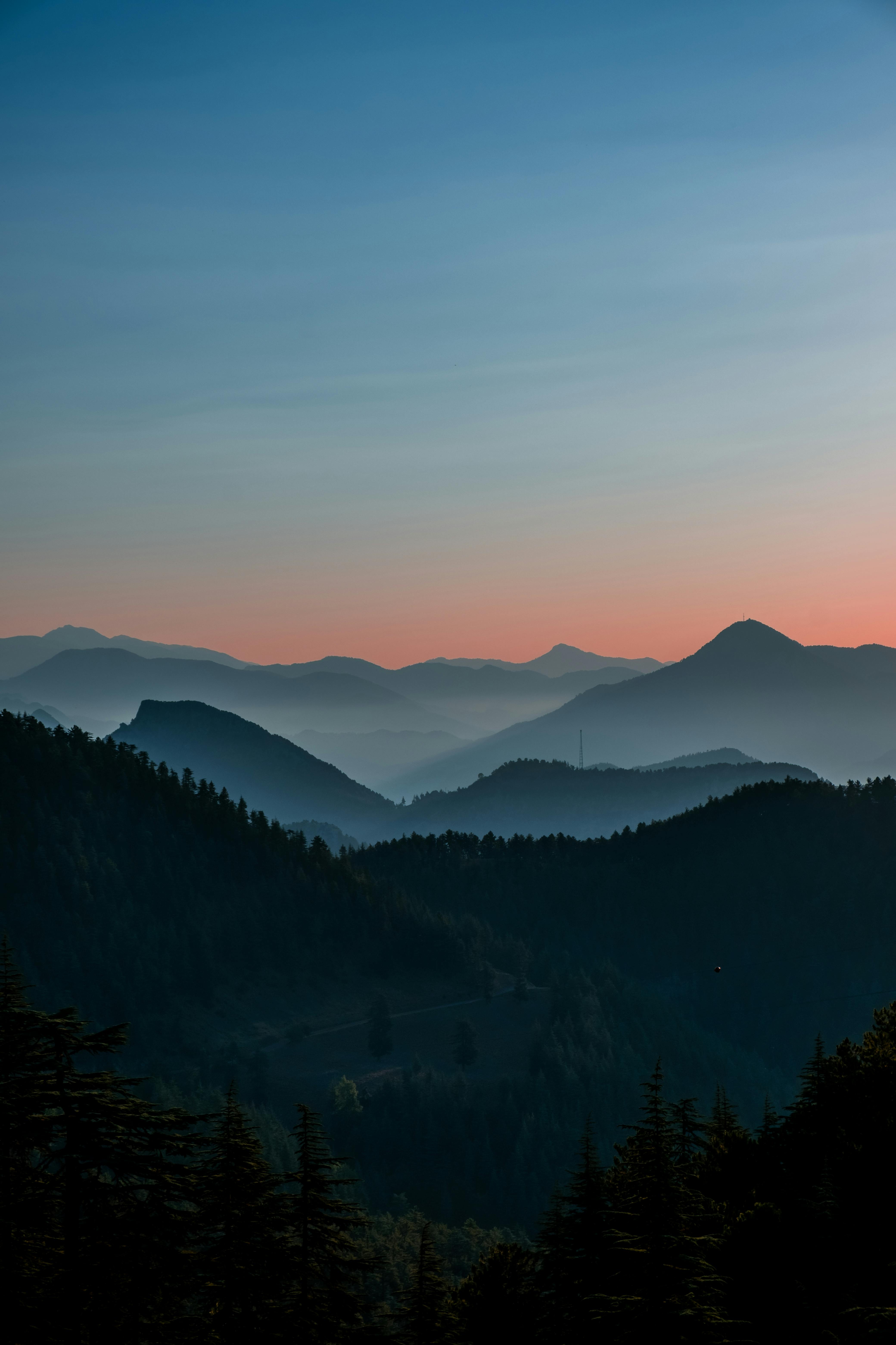 A tranquil mountain landscape with mist and vibrant sunset hues, evoking a sense of calm.