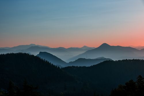 Free Peaceful mountain landscape with mist and colorful sky at sunrise. Stock Photo