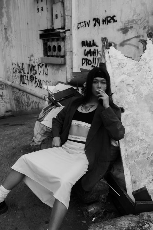 Free Black and white portrait of a woman smoking in an urban setting with graffiti. Stock Photo