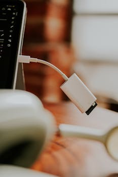 A close-up shot of a white adapter connected to a laptop, showcasing connectivity technology.