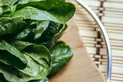 Close-up of fresh spinach leaves on a wooden cutting board, perfect for healthy cooking themes.