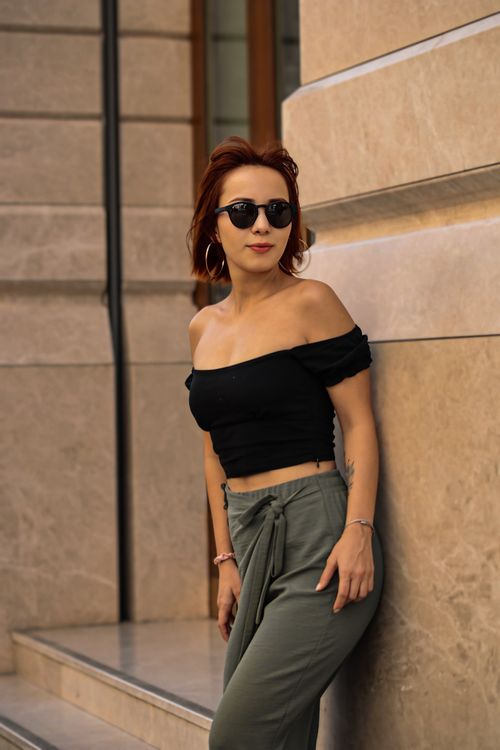 Free Fashionable woman in chic outfit poses confidently by urban architecture. Stock Photo