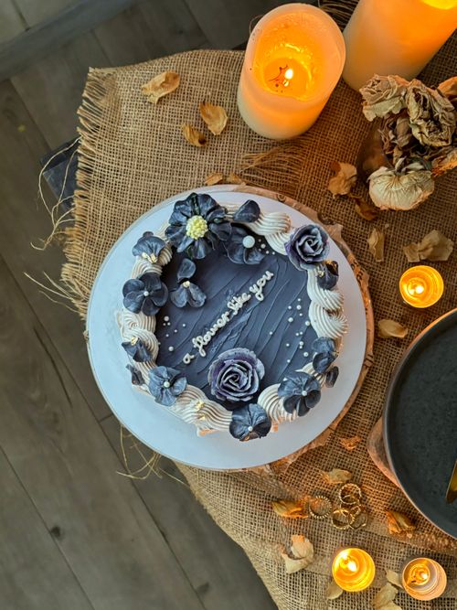 Free Top view of a floral cake surrounded by candles and rustic decor, perfect for celebrations. Stock Photo