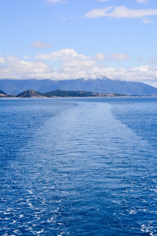 Free Peaceful seascape with turquoise waters and mountains under a clear blue sky. Stock Photo