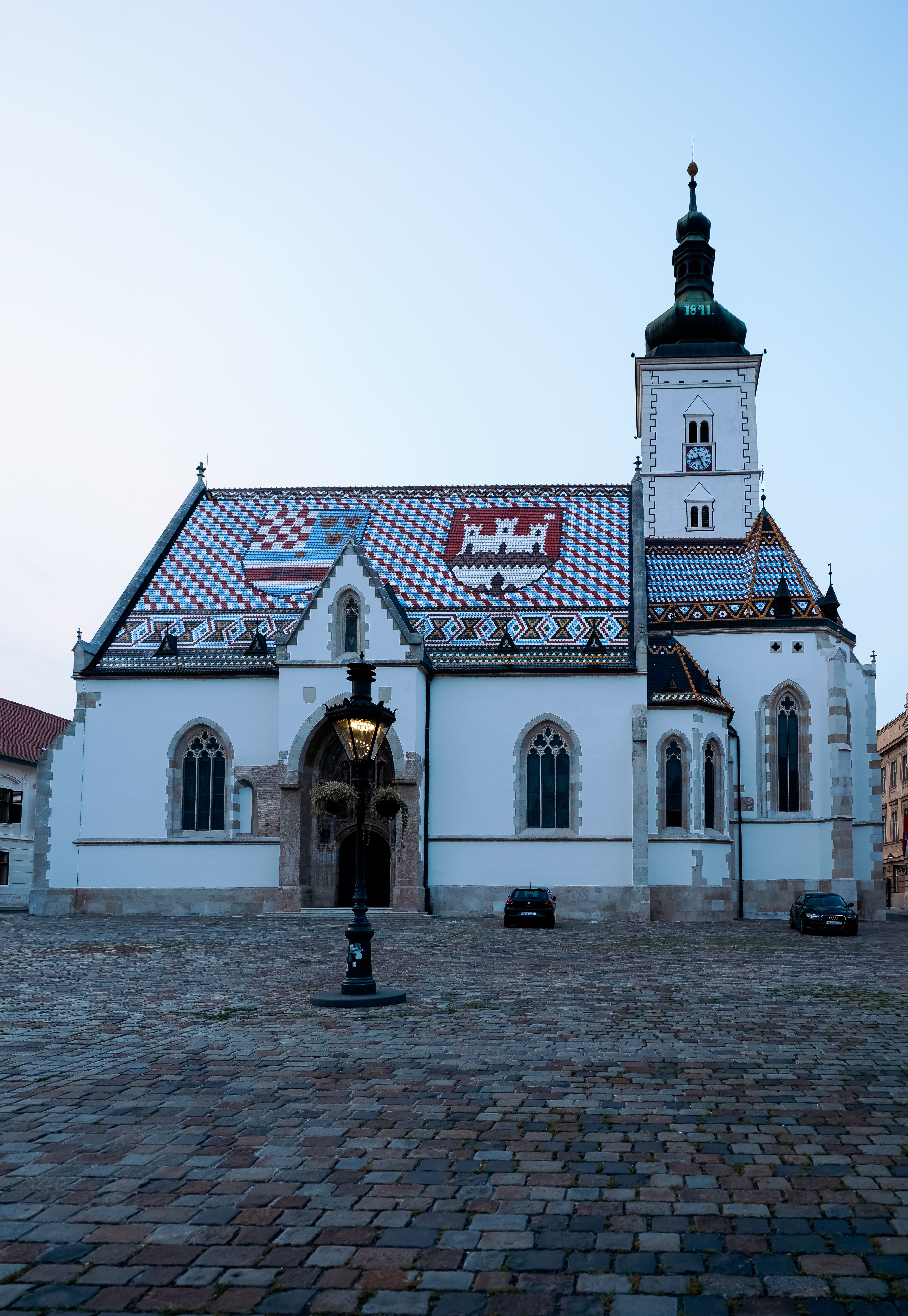 Stunning view of St. Mark's Church in Zagreb's historic square, featuring its vibrant tiled roof at dusk.