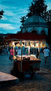 Charming evening street market with a lit cart and majestic dome backdrop.