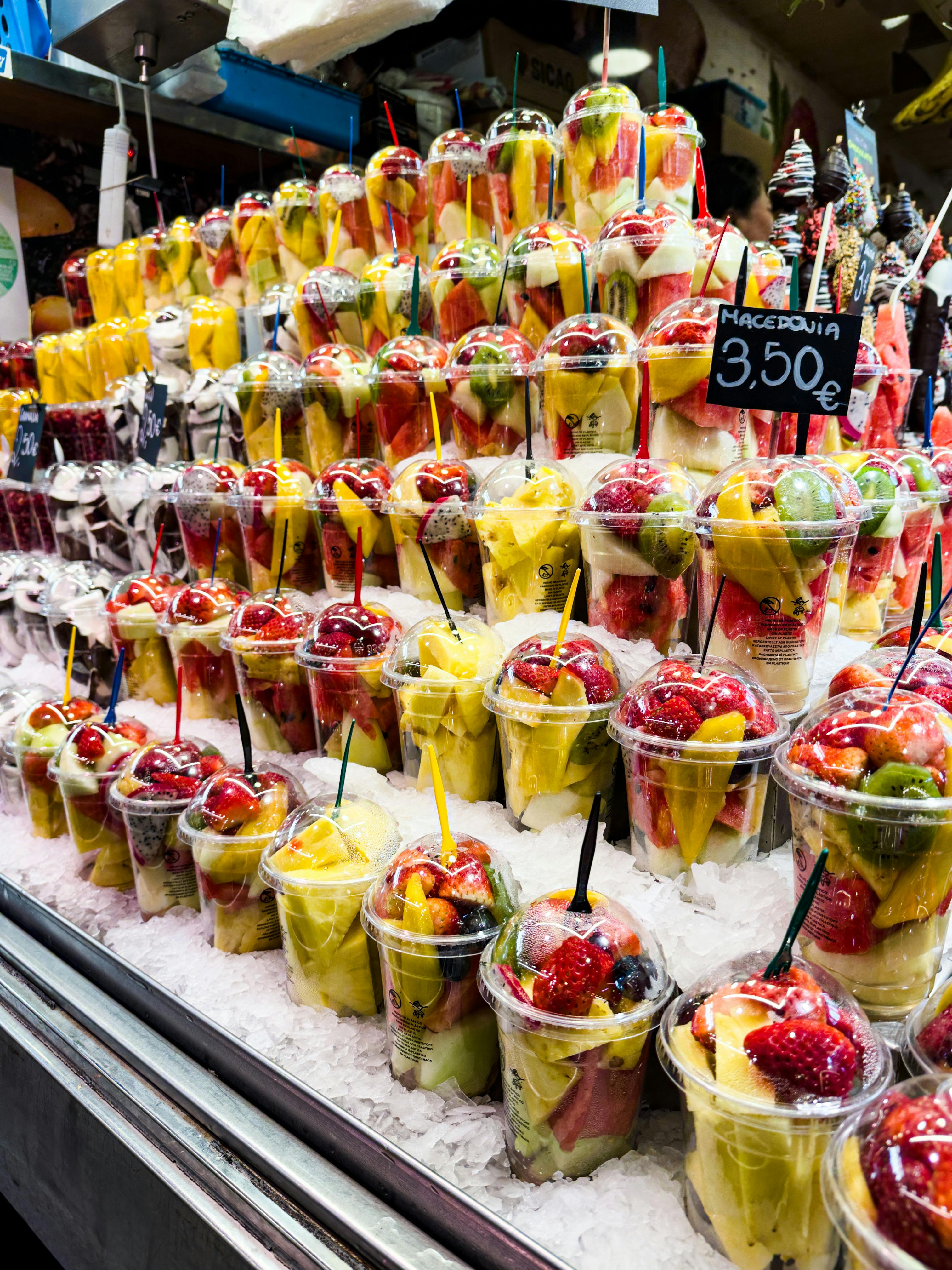 a display of fruit in cups with ice