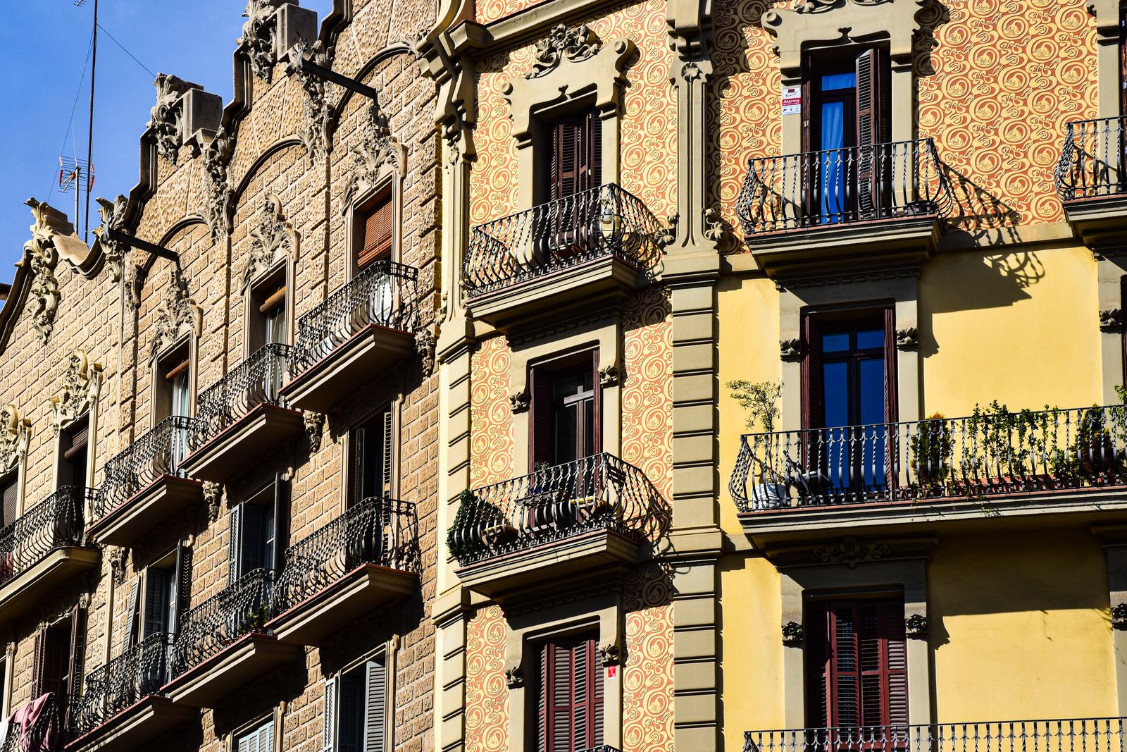 Façade colorée d'un petit hôtel barcelonais dans une rue piétonne du quartier gothique