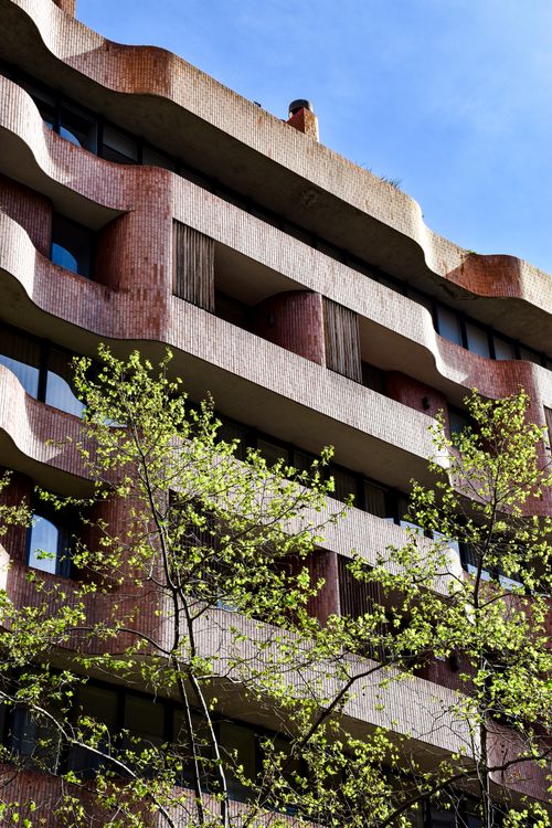 Free Explore the distinctive architectural style of a residential building in Barcelona with natural brick and urban foliage. Stock Photo