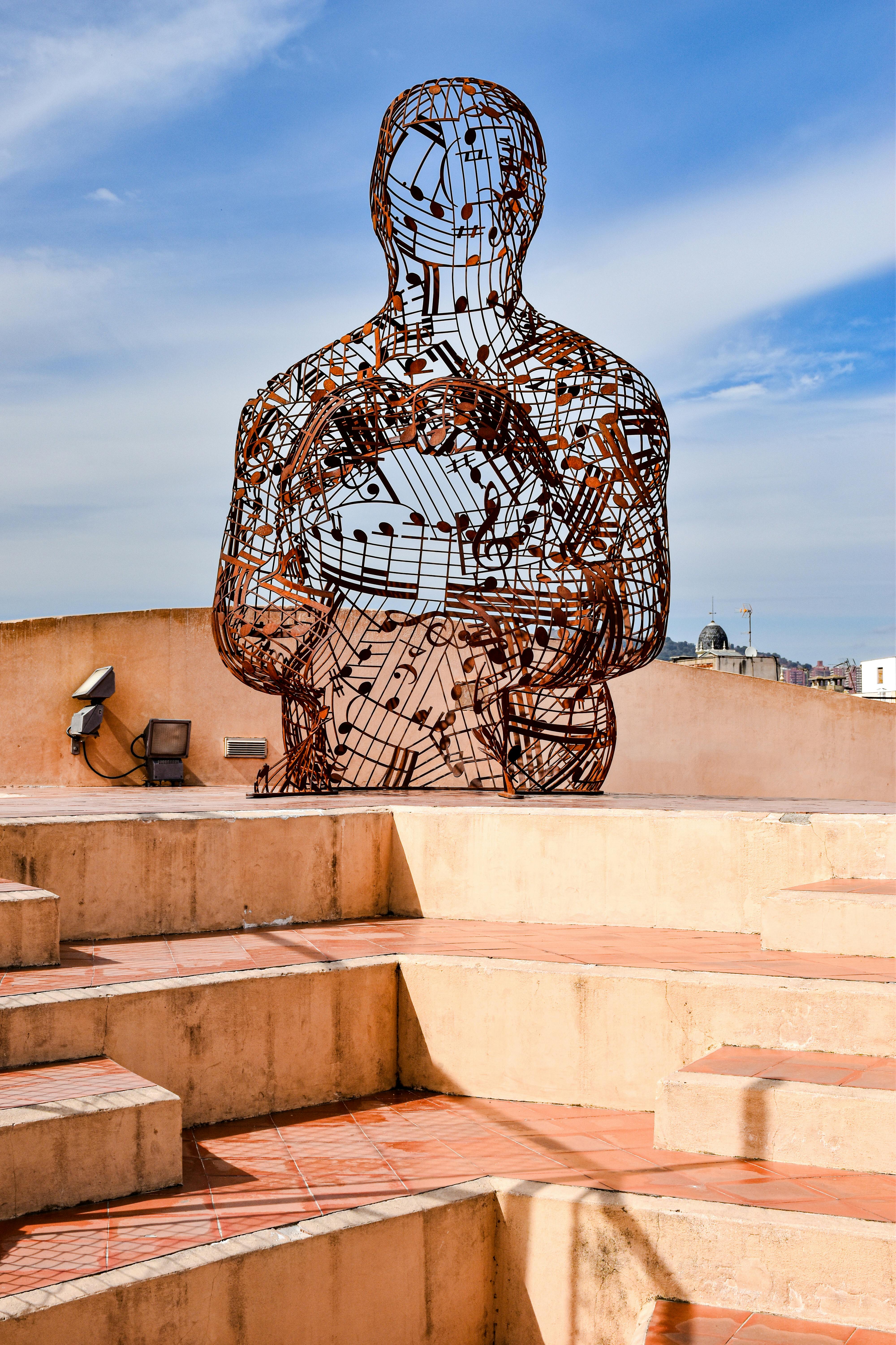 a sculpture of a man sitting on top of stairs