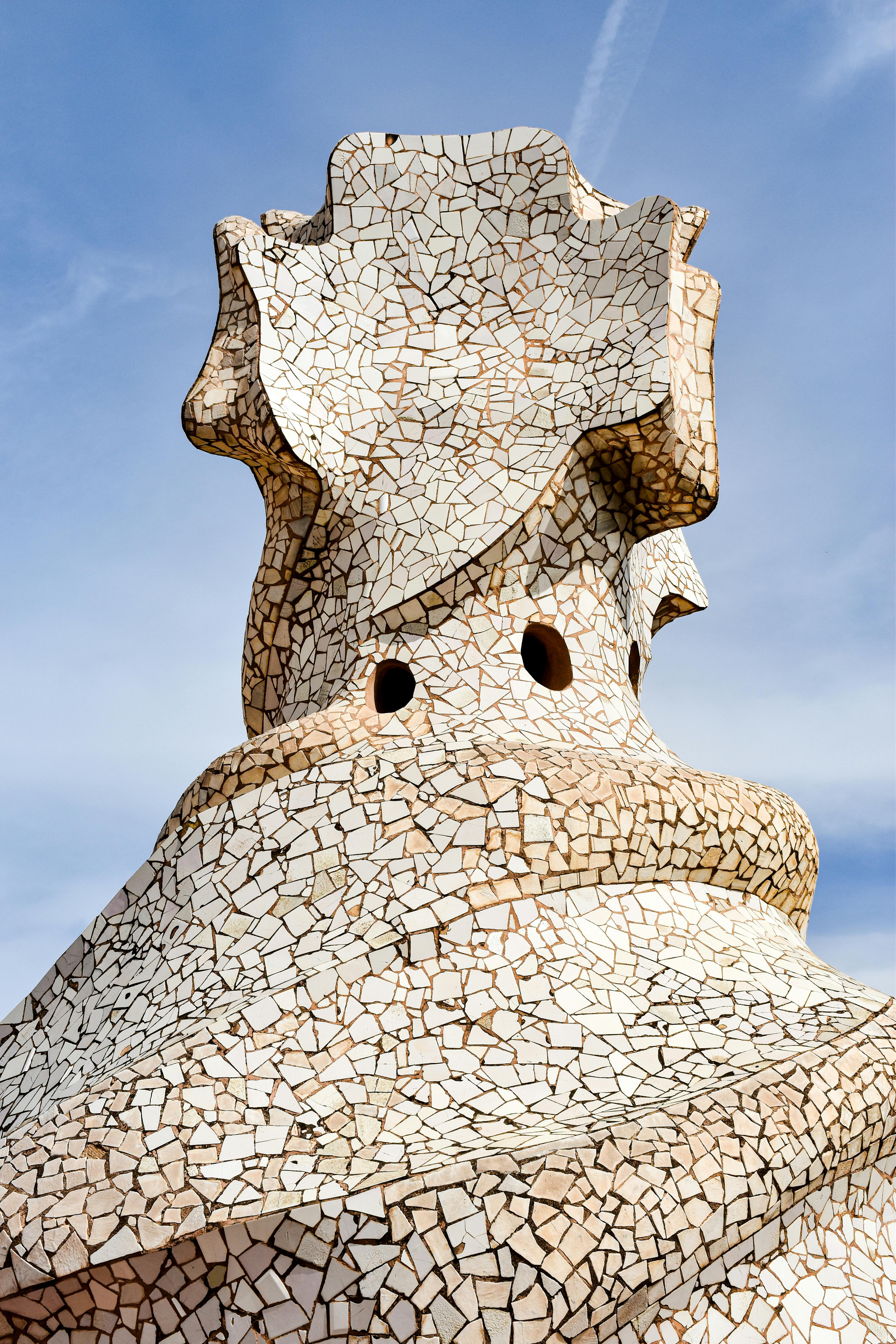 the top of a building with a large stone sculpture