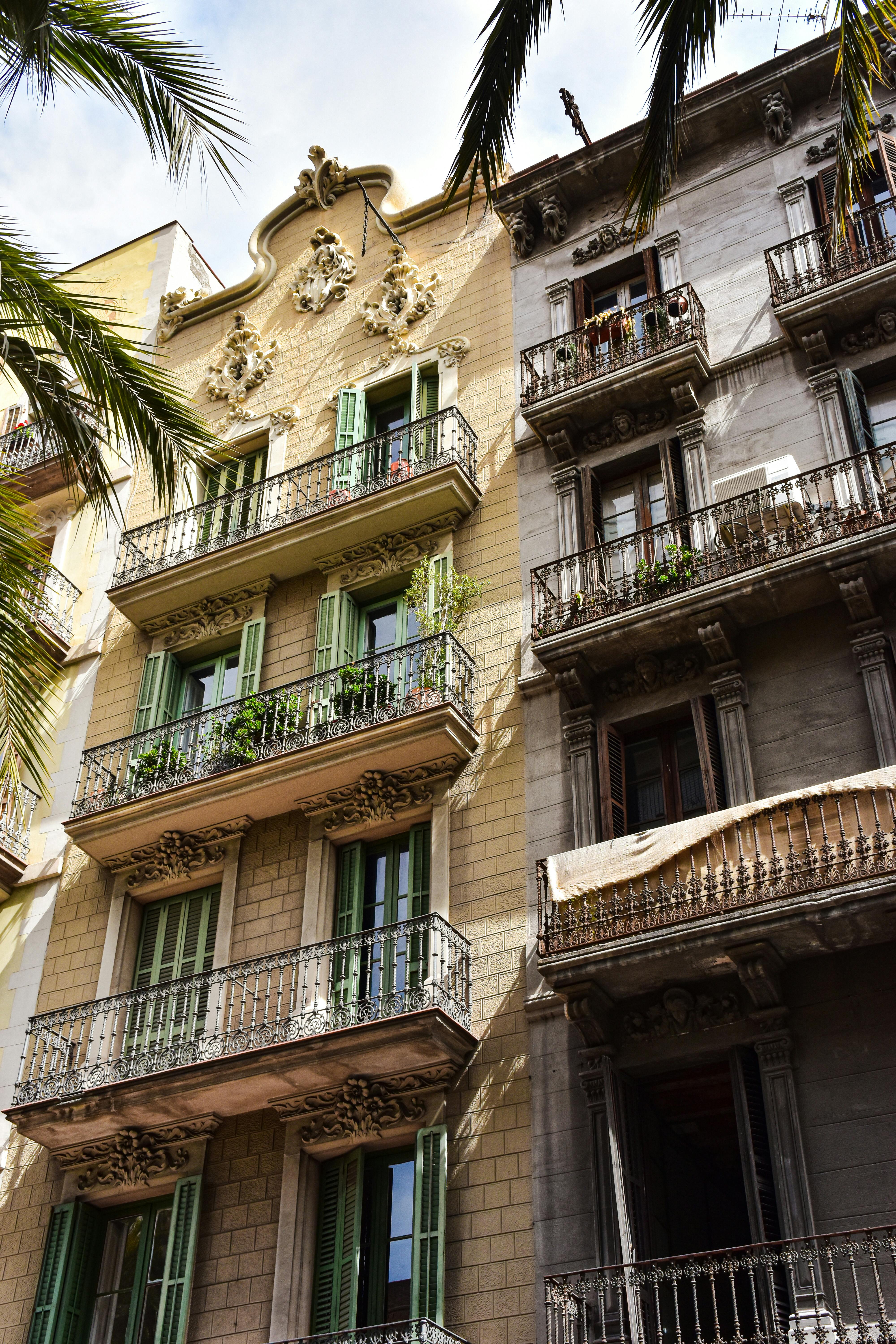 a building with balconies and palm trees in front of it