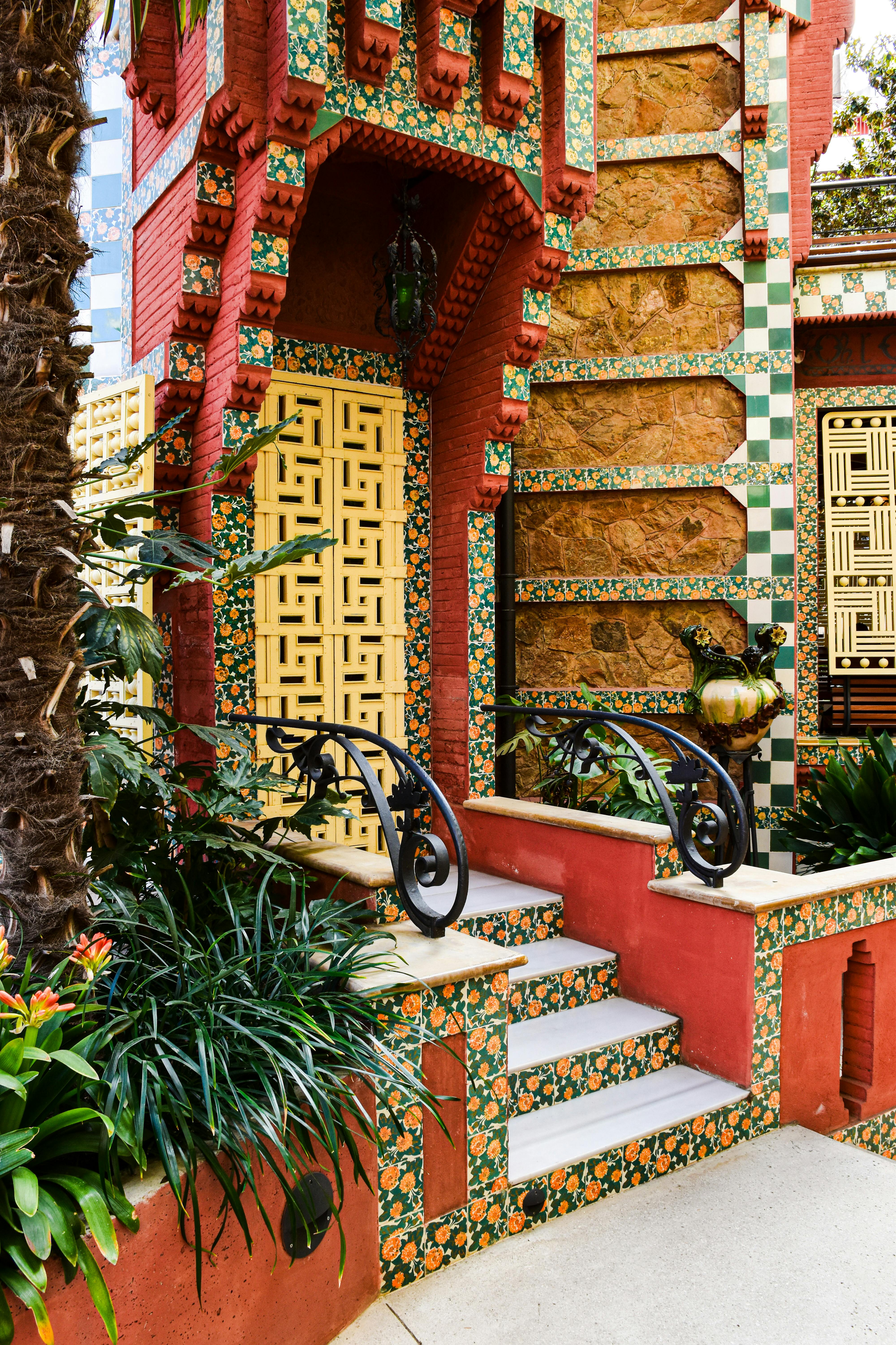 a colorful building with a red door and a green tiled roof