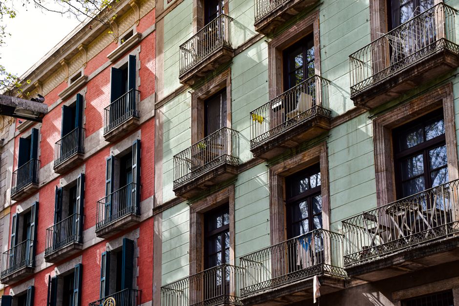 Fachada vibrante de un edificio tradicional en Barcelona que muestra características arquitectónicas distintas y balcones.