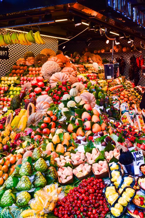 Free Vibrant display of fresh fruits at a bustling market stall in Barcelona, Spain. Stock Photo