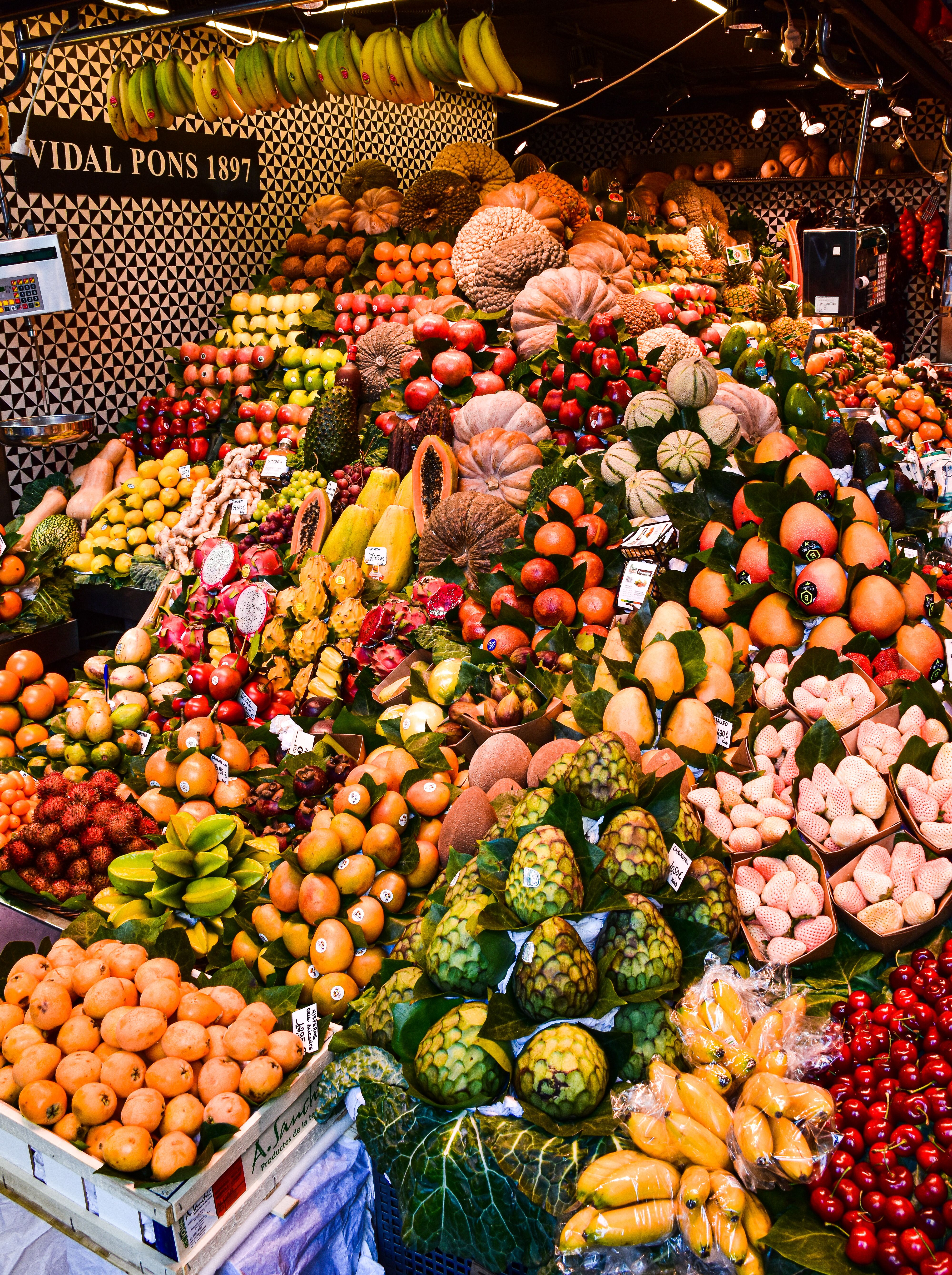 Colorful display of fruits at a market stall in Barcelona, Spain, showcasing seasonal produce.