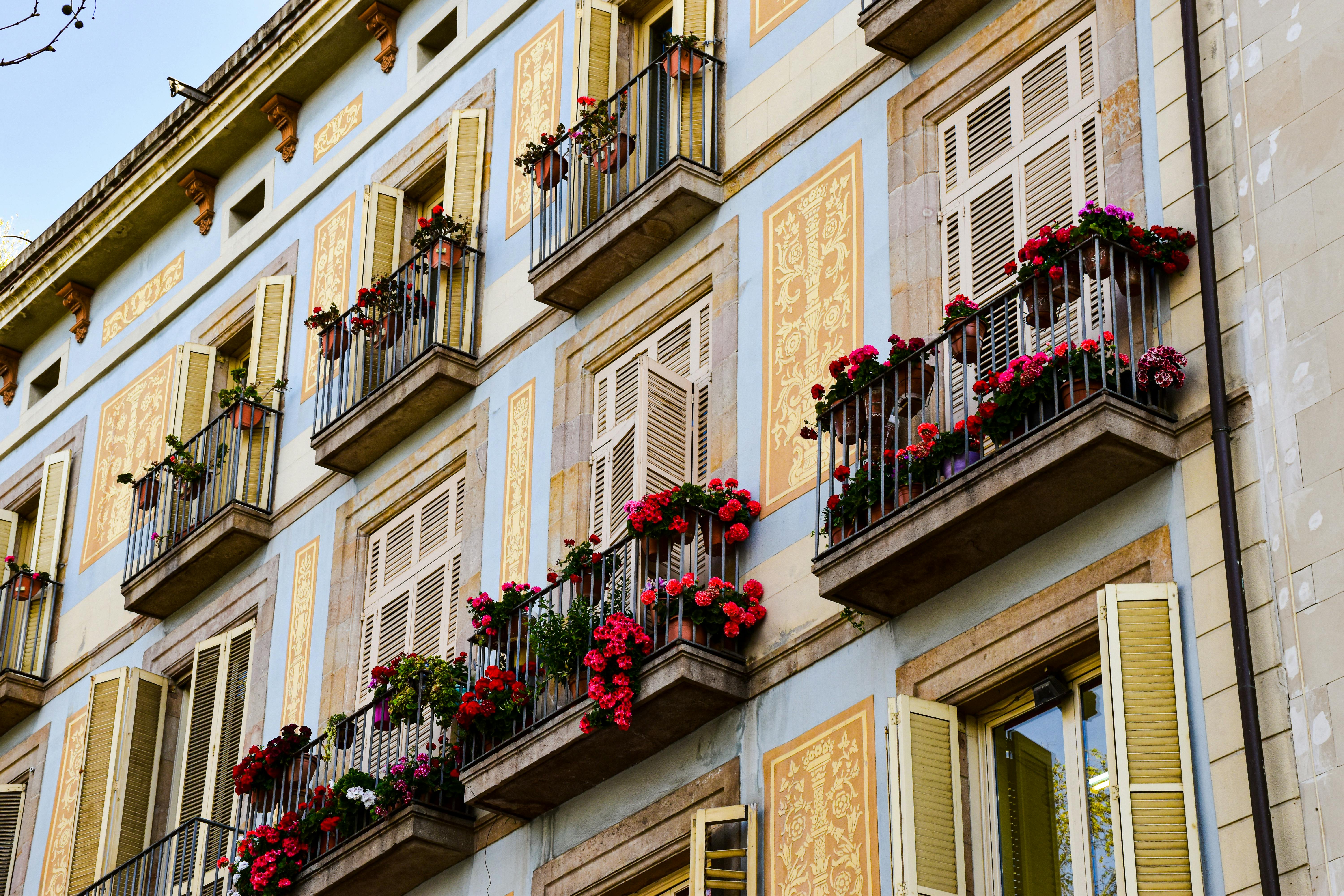 a building with balconies and flowers on the balconies