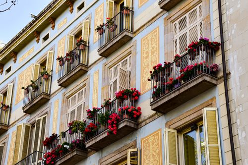 Free Colorful floral balconies on a traditional Barcelona apartment facade, capturing vibrant urban charm. Stock Photo