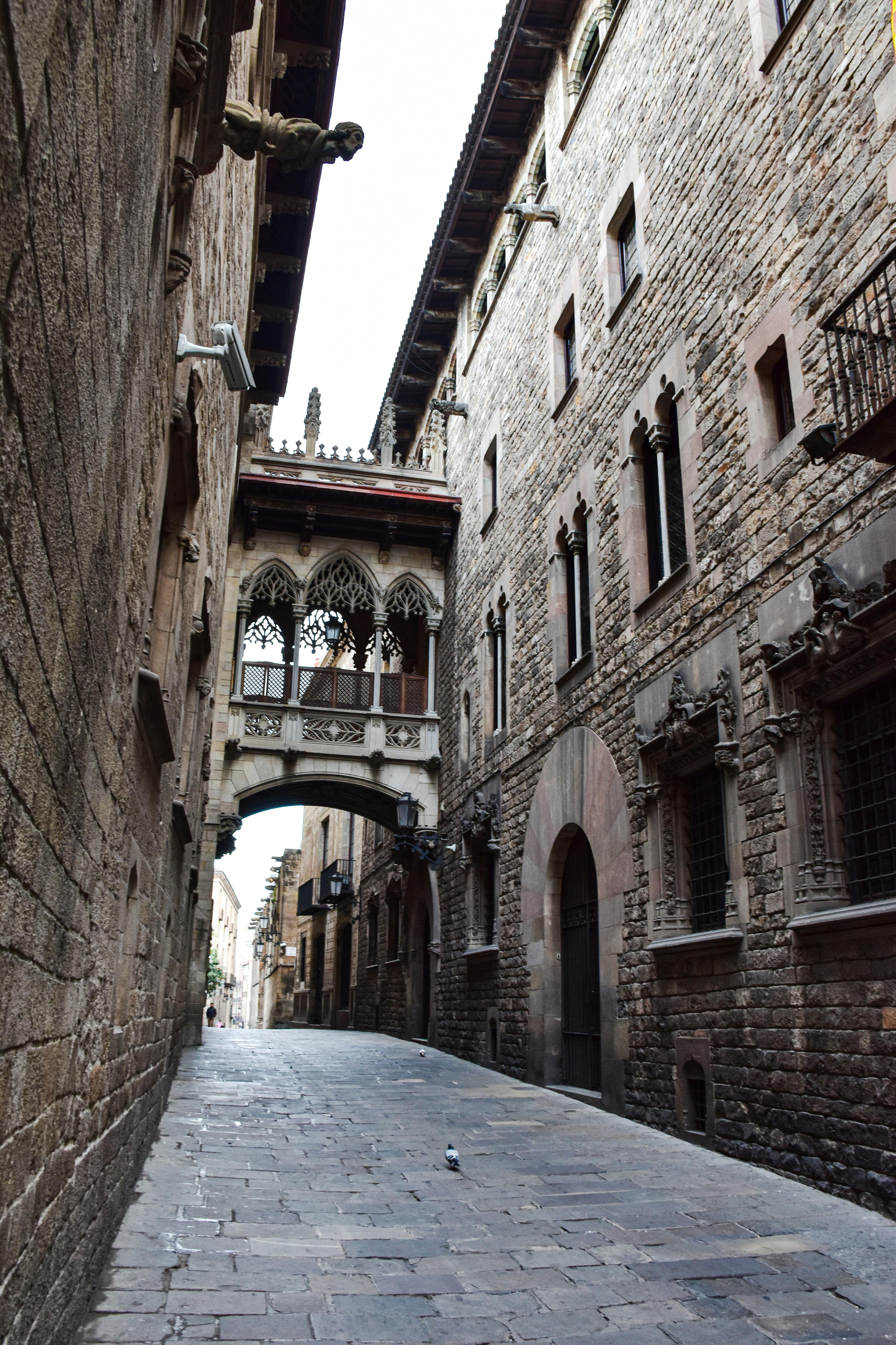 a narrow street with a stone archway and buildings