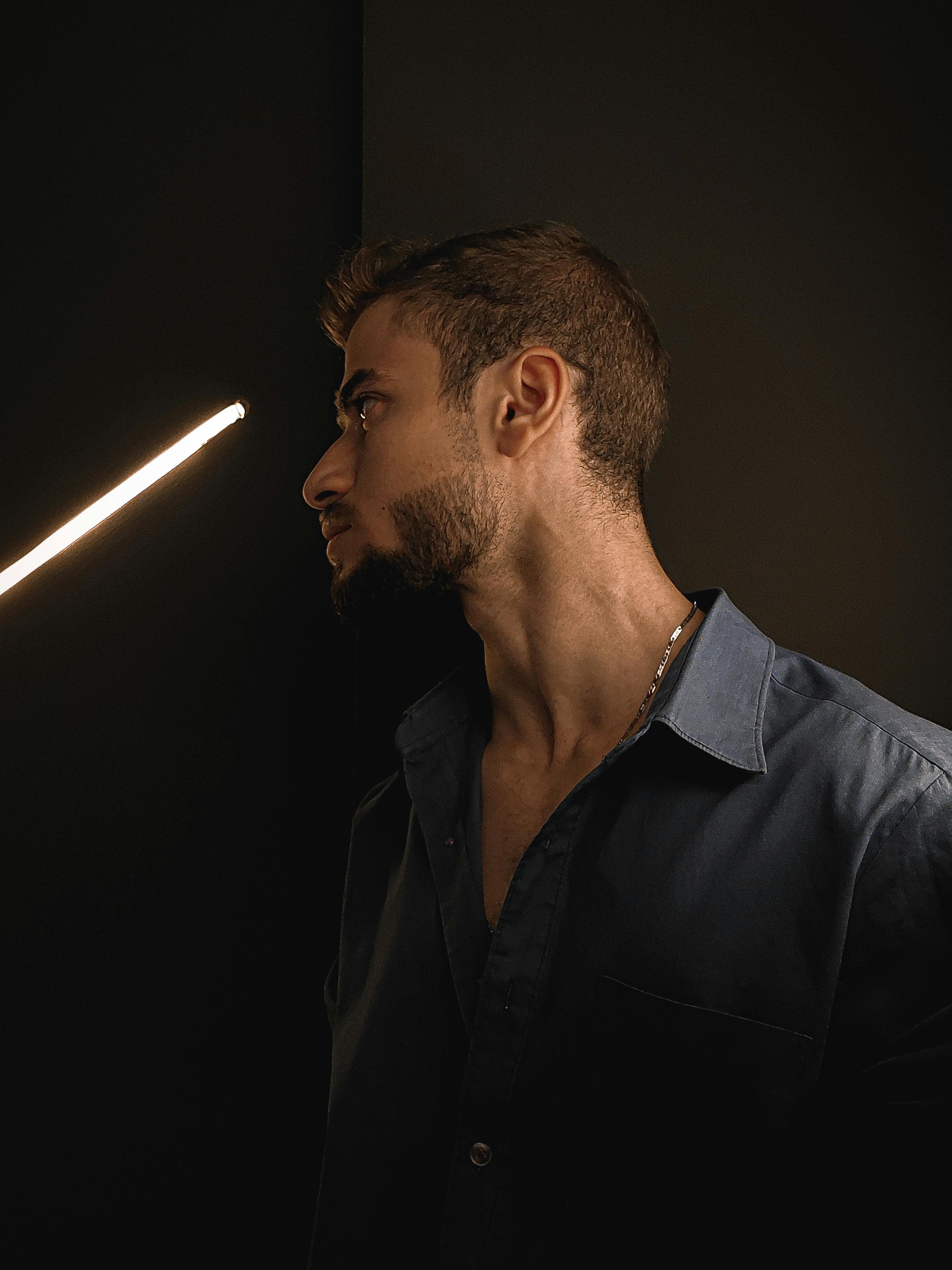 Introspective portrait of a man in dramatic lighting, conveying depth and emotion.
