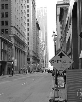 Monochrome street view captures architectural structures and construction sign in Toronto, Canada.