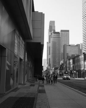 A black and white photo of a Toronto street with modern high-rise buildings.