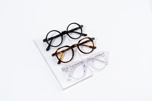 Three pairs of eyeglasses displayed on a white surface showcasing classic and stylish fashion eyewear.