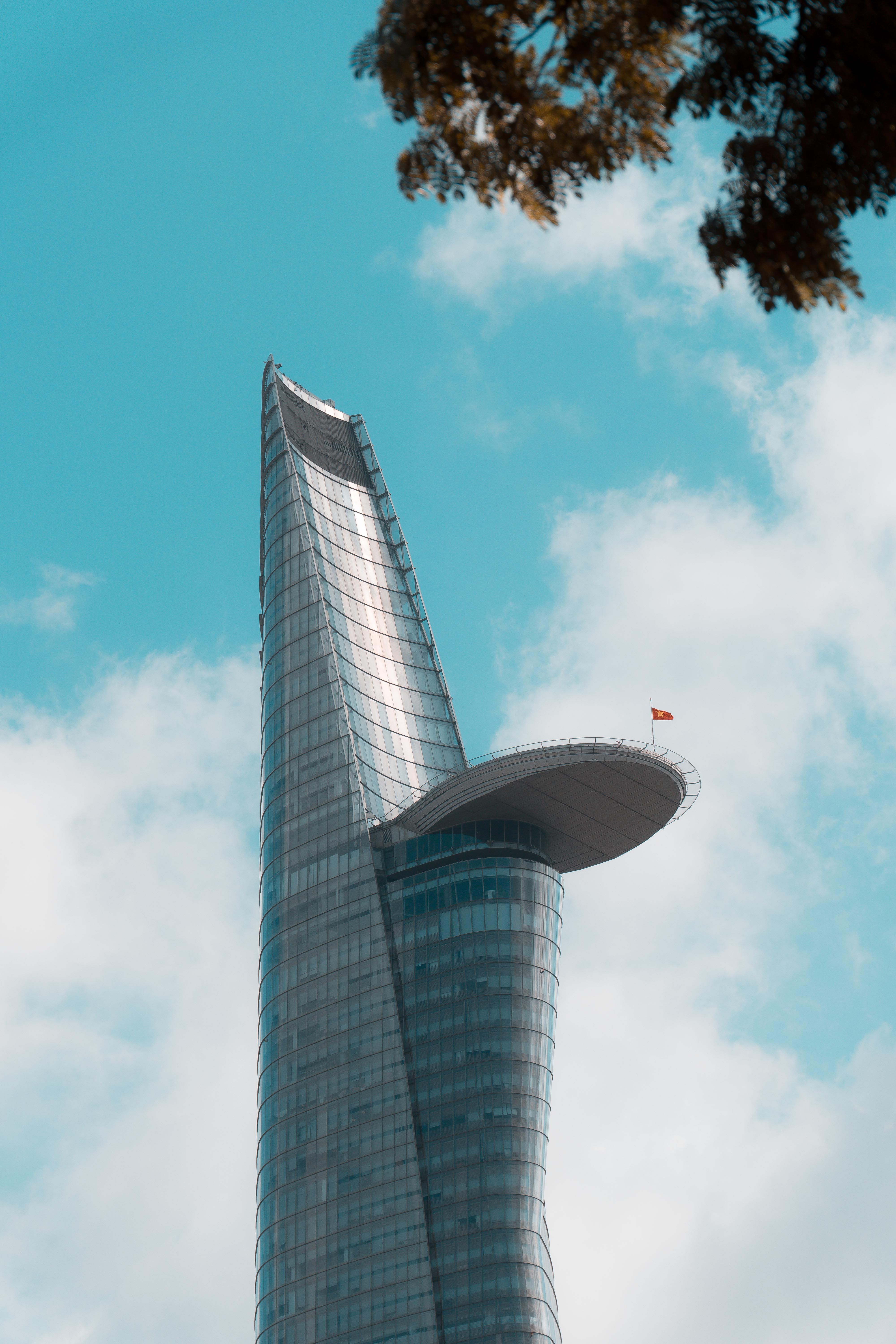 A tall building with a flag flying in the air · Free Stock Photo