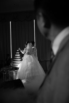 A romantic black and white photo of a bride and groom at their wedding ceremony with elegant details.