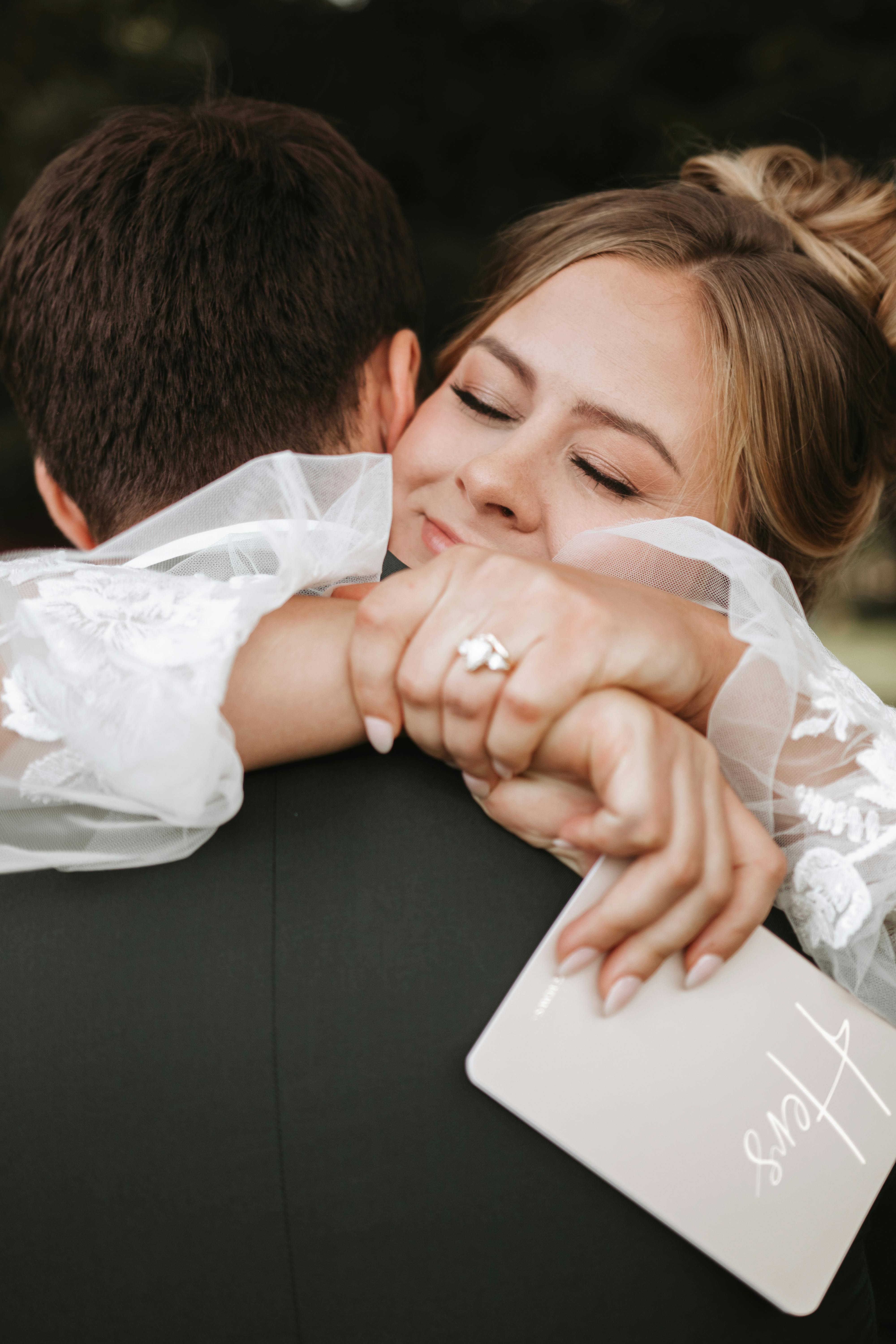 A close-up of a joyful bride embracing her groom outdoors.