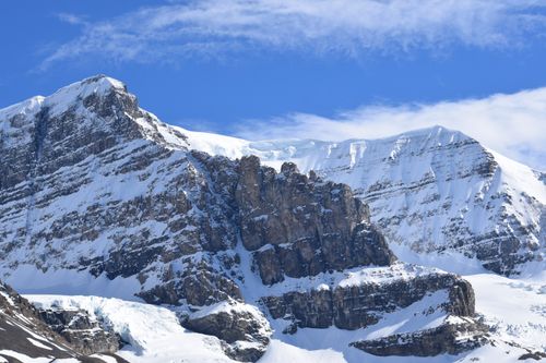 Free Breathtaking view of snow-covered Rocky Mountains under a vibrant blue sky in Alberta, Canada. Stock Photo