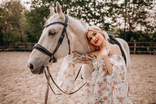 Free A young woman posing with a horse outdoors in a summer setting. Stock Photo