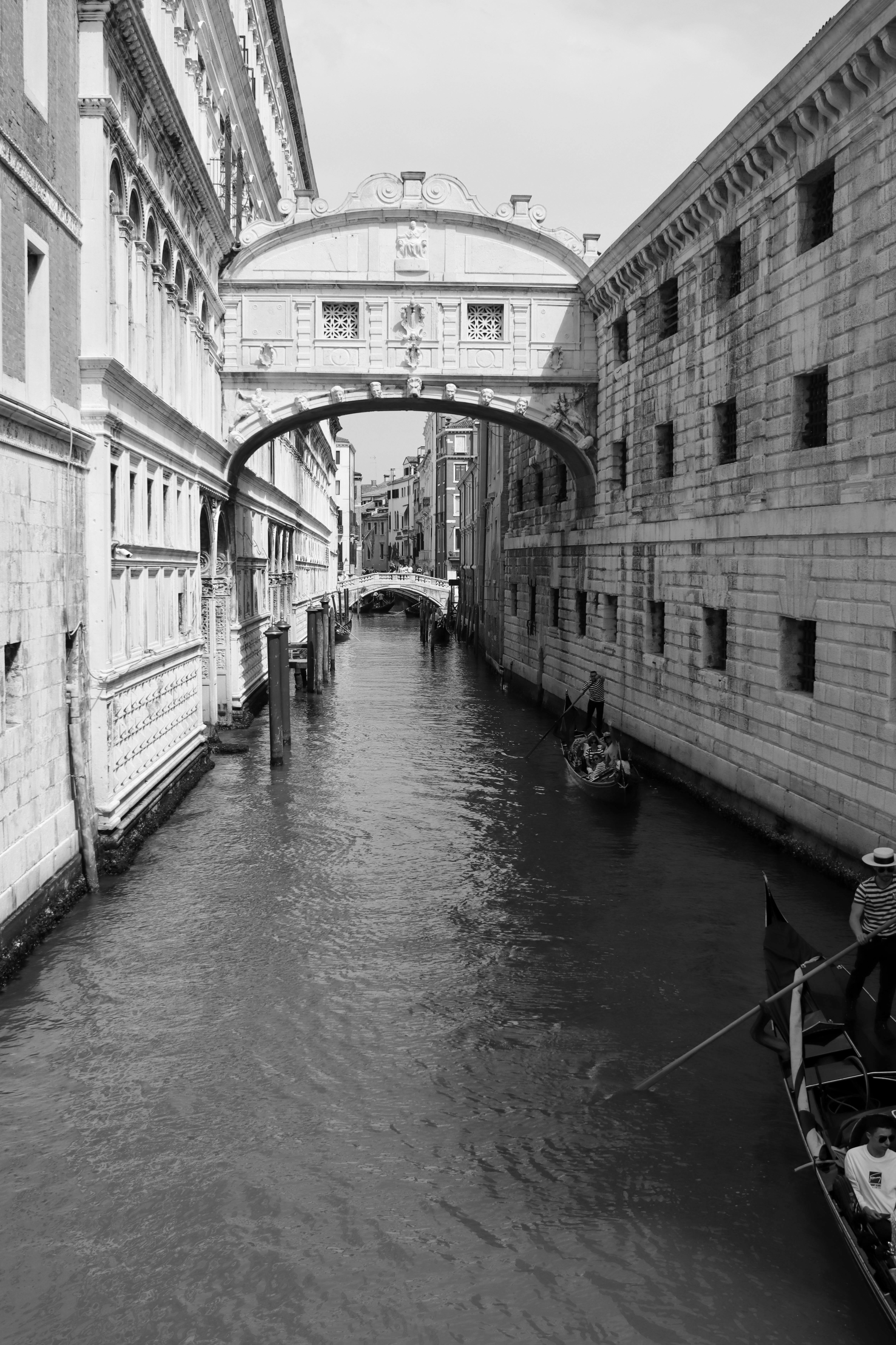 Iconic Bridge of Sighs over a canal in Venice captured in monochrome.