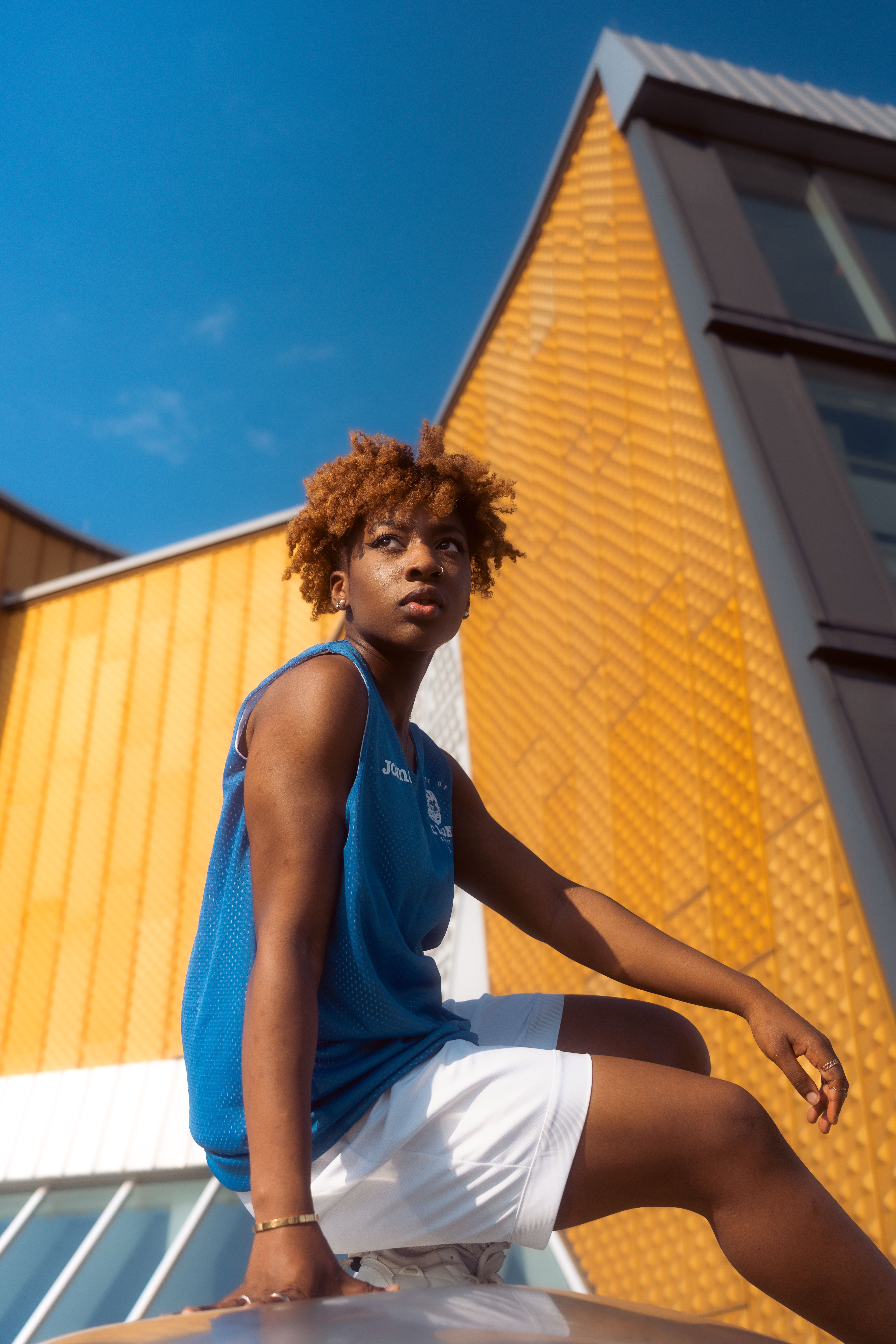 Portrait of young man sitting against modern architecture in Berlin.