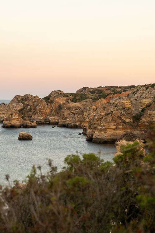 Free Serene coastal landscape featuring Algarve's cliffs at sunset, offering a tranquil and picturesque view. Stock Photo