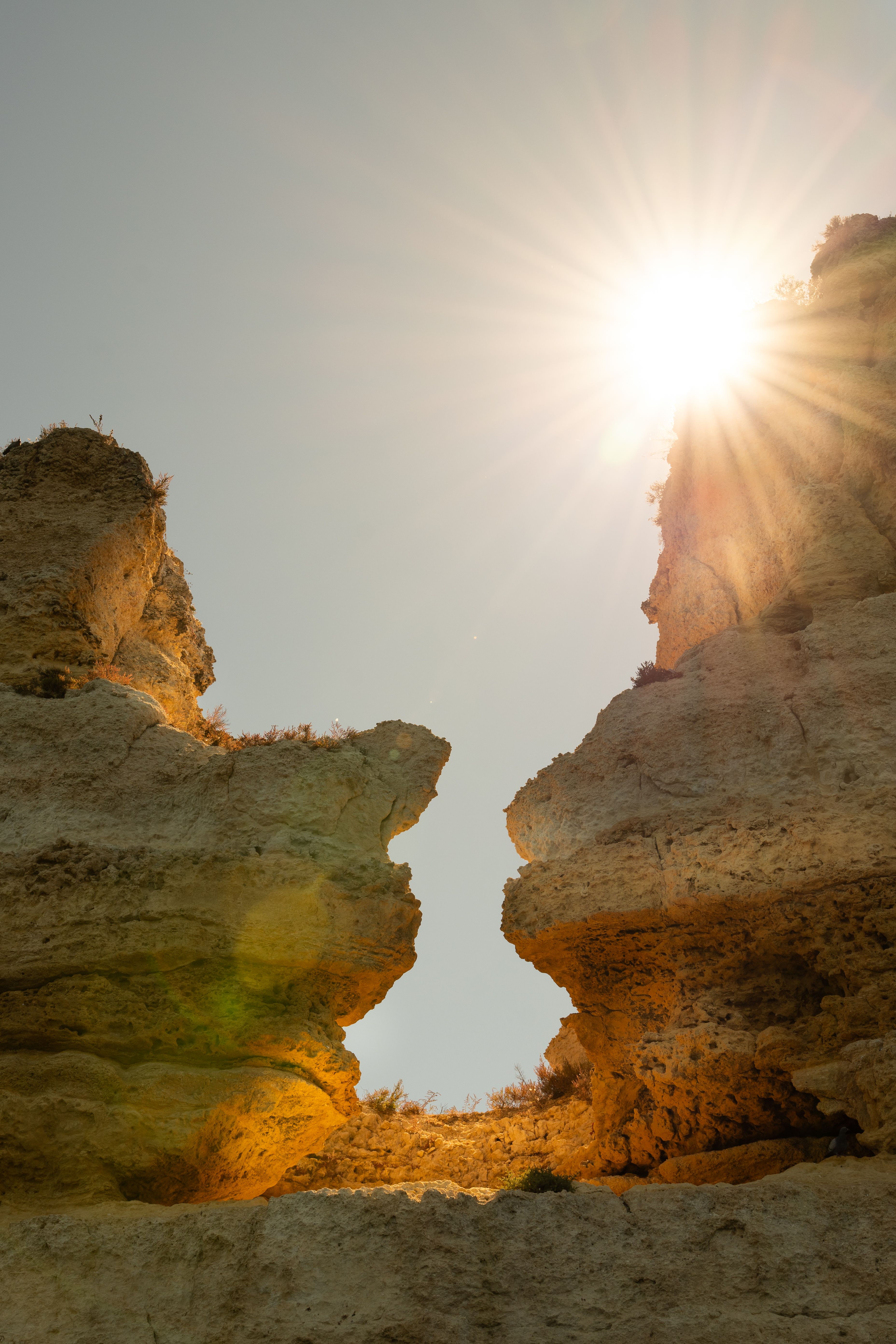 The sun shines through the cracks of two rocks · Free Stock Photo