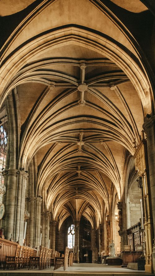Free Beautifully detailed interior of a Gothic cathedral showcasing stunning vaulted ceilings and arches. Stock Photo