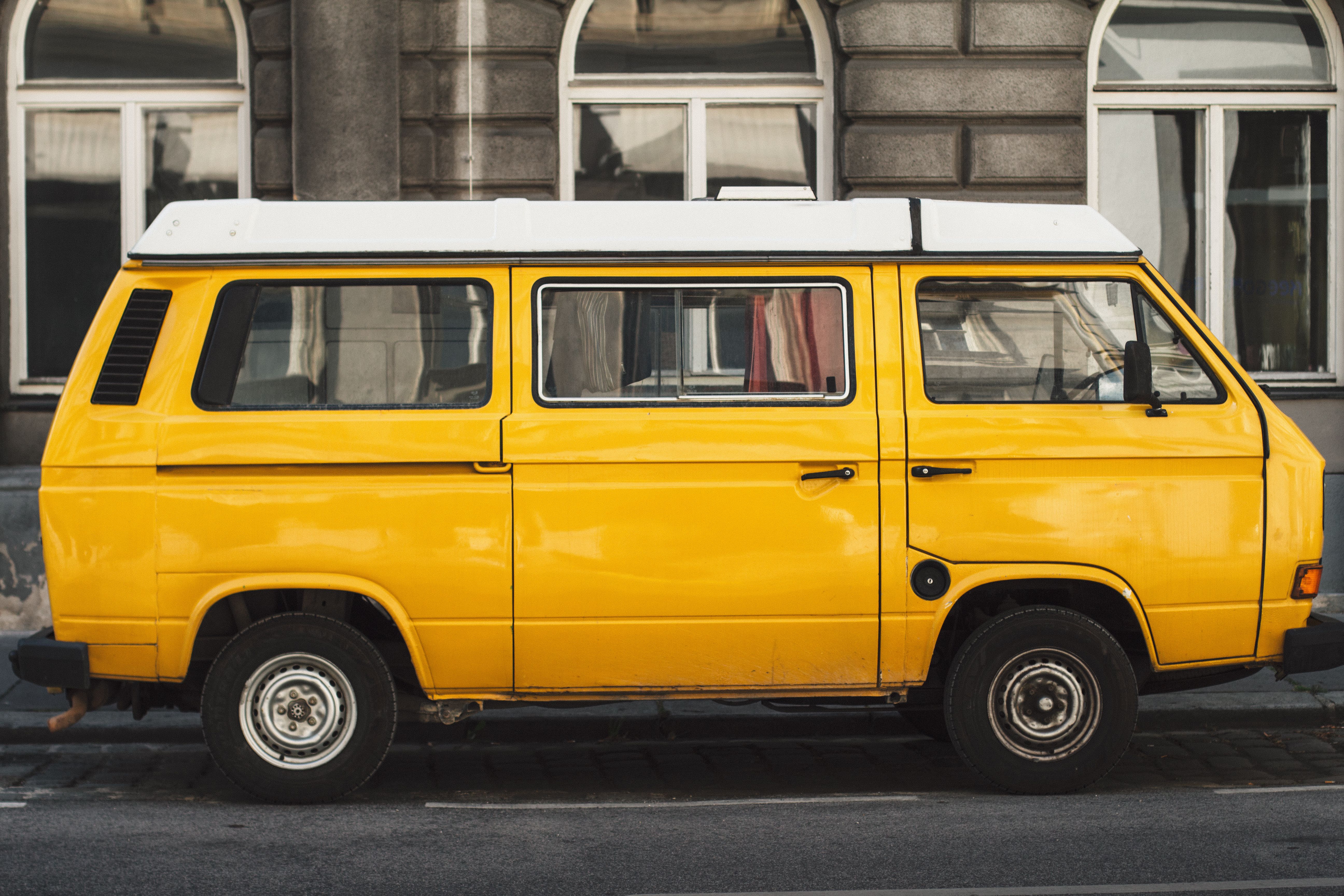 Retro yellow van parked in front of classic Viennese architecture