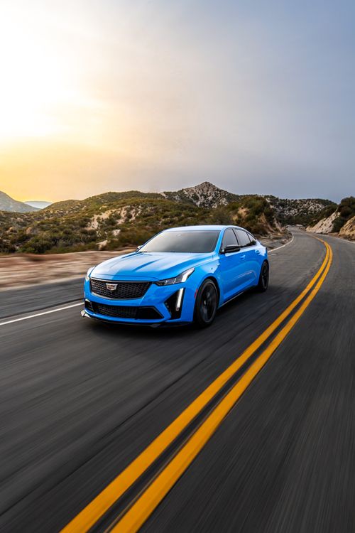 Free Blue sedan racing on a mountain highway during sunset in Los Angeles, California. Stock Photo