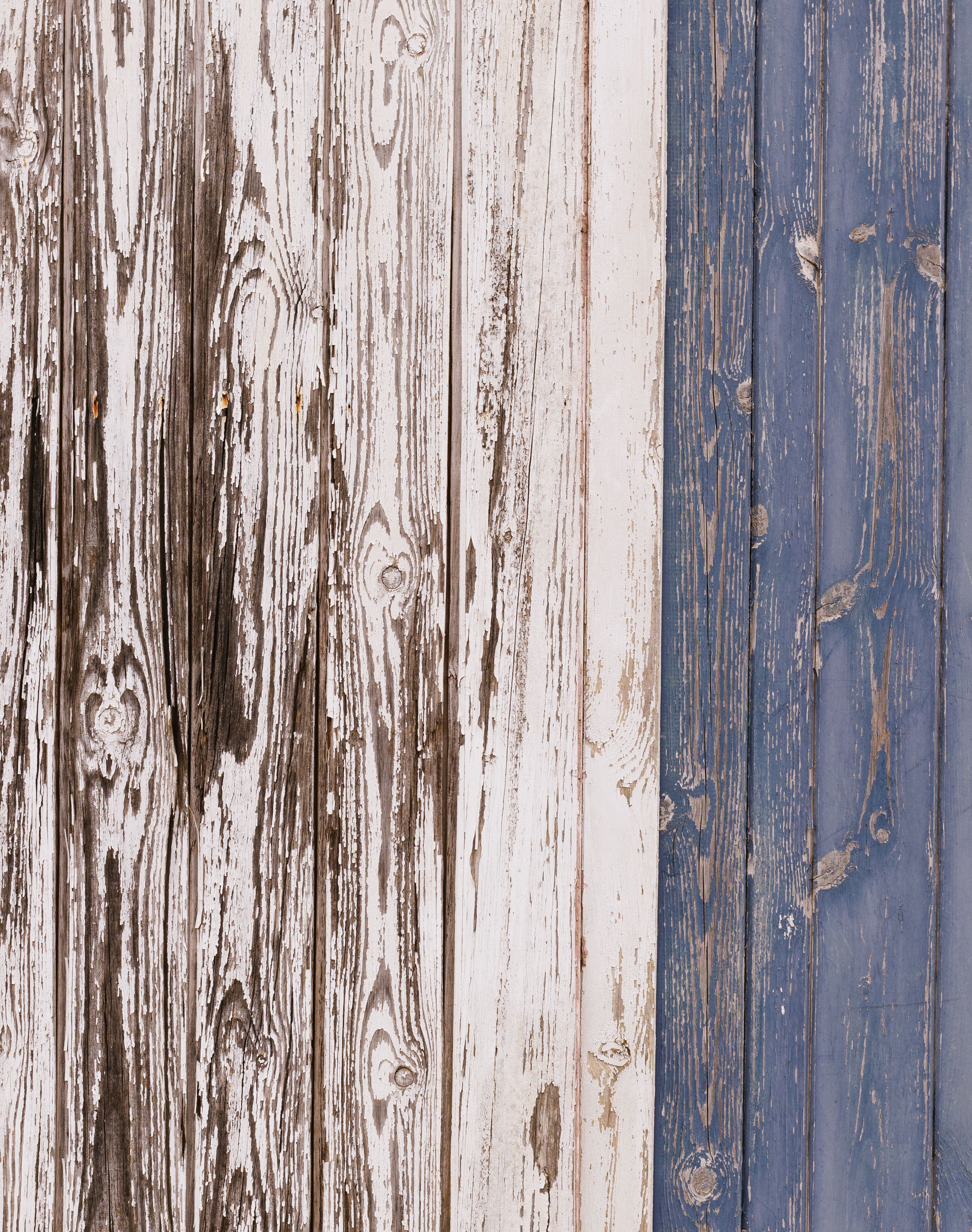 Aged wooden planks with blue and white paint showcasing vintage rustic texture.