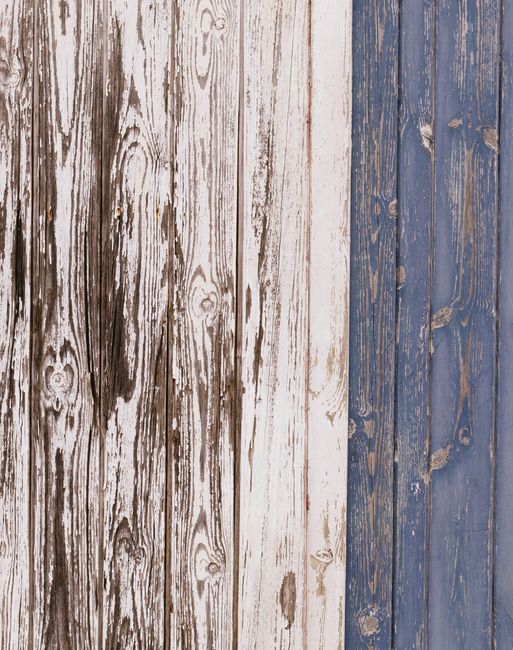 Aged wooden planks with blue and white paint showcasing vintage rustic texture.
