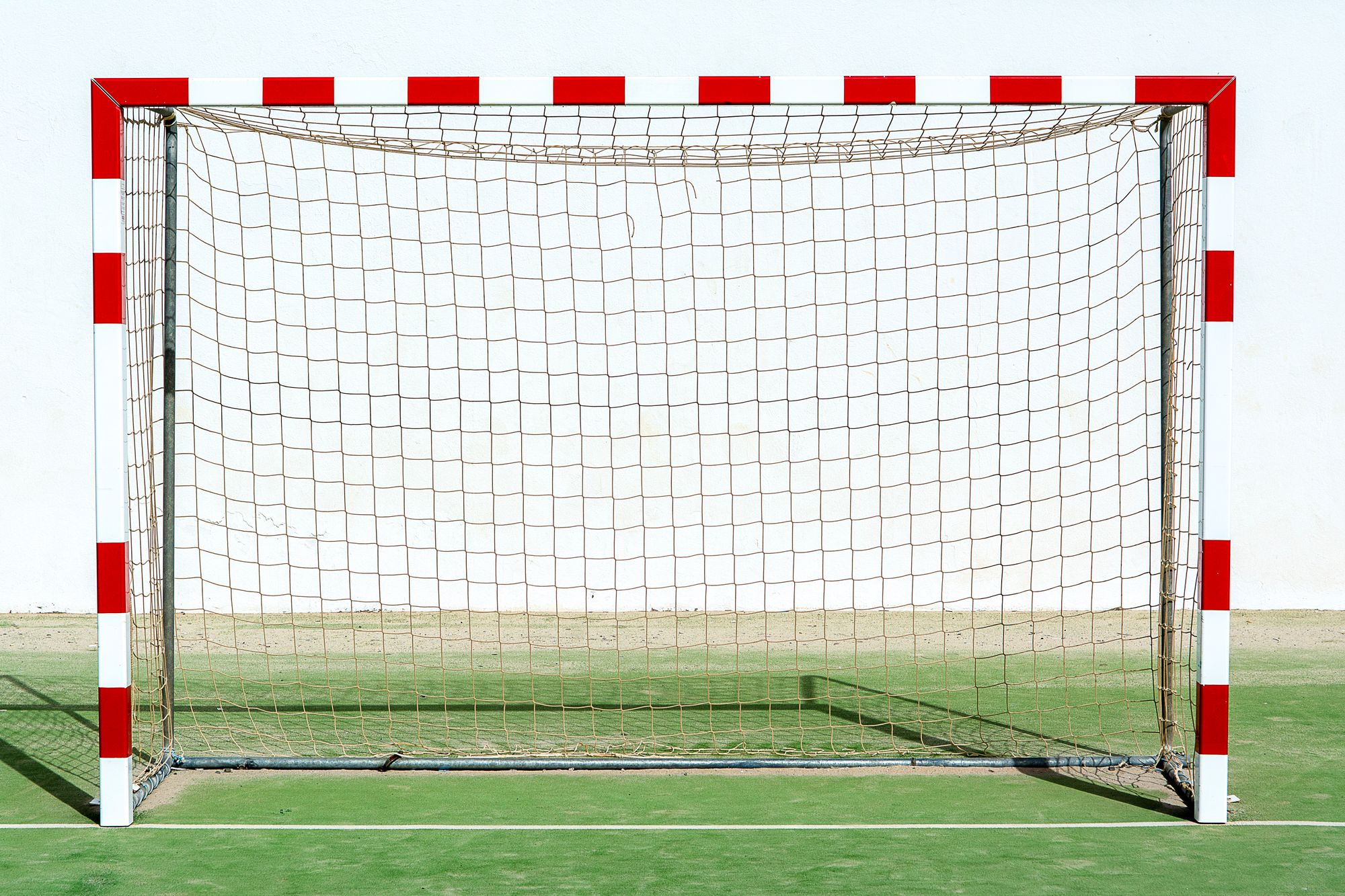 Portería de fútbol vacía con la red tensa dentro de un estadio