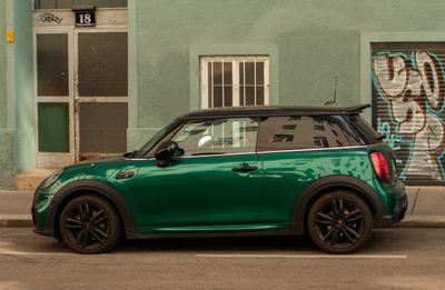 Green compact hatchback parked on a city street — photo by Raymond Petrik on Pexels