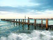 在宁静的日落景色中，可以看到伸入大海的木码头，海浪和遥远的地平线尽收眼底