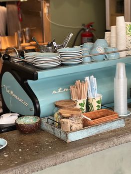 A quaint vintage coffee shop counter with pastel dishes and a retro vibe.