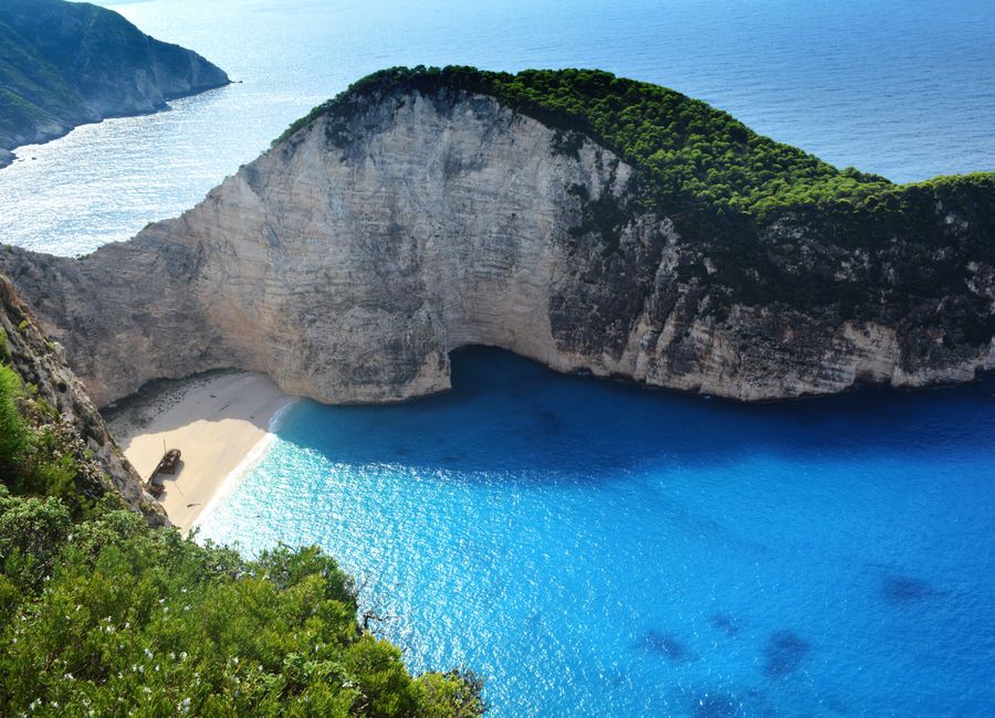 A breathtaking aerial view of Navagio Beach with turquoise waters and lush greenery.