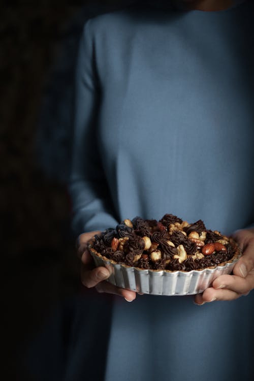 Person Holding Chocolate Pie with Nuts